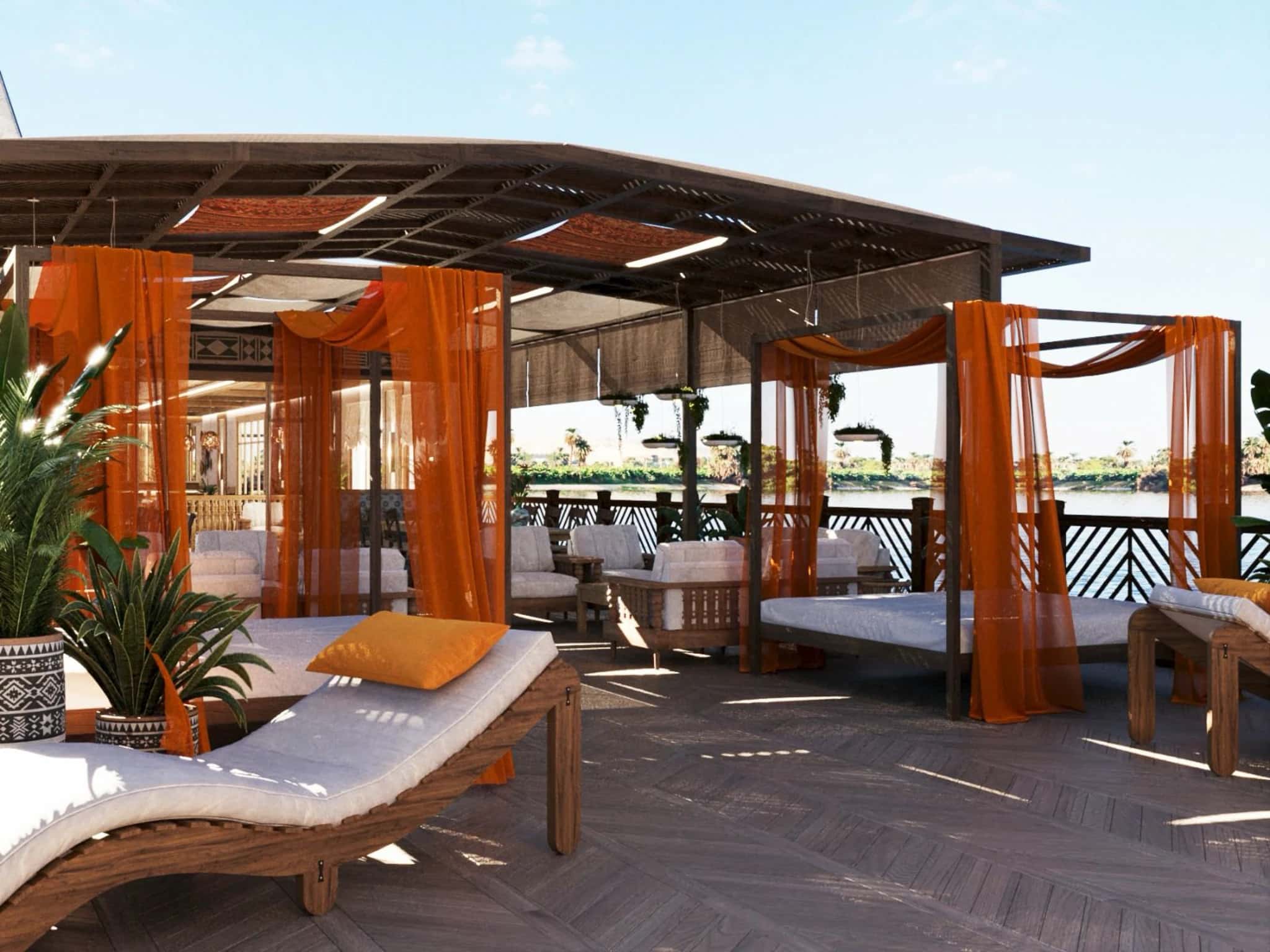 Deck Lounge – Dahabeya Nonia & Nofret Área exterior con camas balinesas y cortinas naranjas en la cubierta de la dahabeya Nonia & Nofret, con vistas al río Nilo.